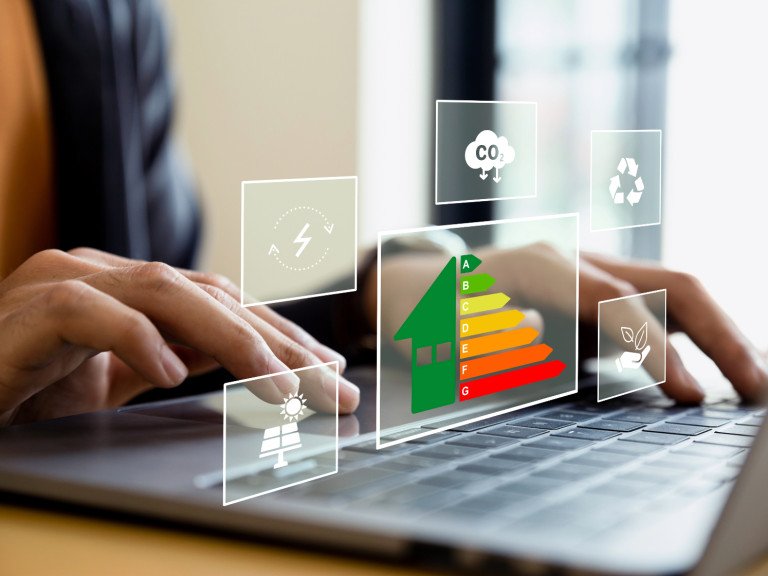 person typing on computer keyboard. graph and illustrations of sustainability symbols