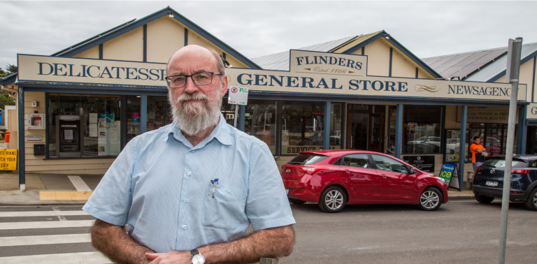 owner of flinders general store posing in front of flinders general store