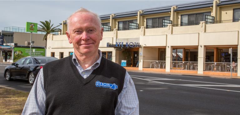 owner of rye hotel smiling in front of rye hotel